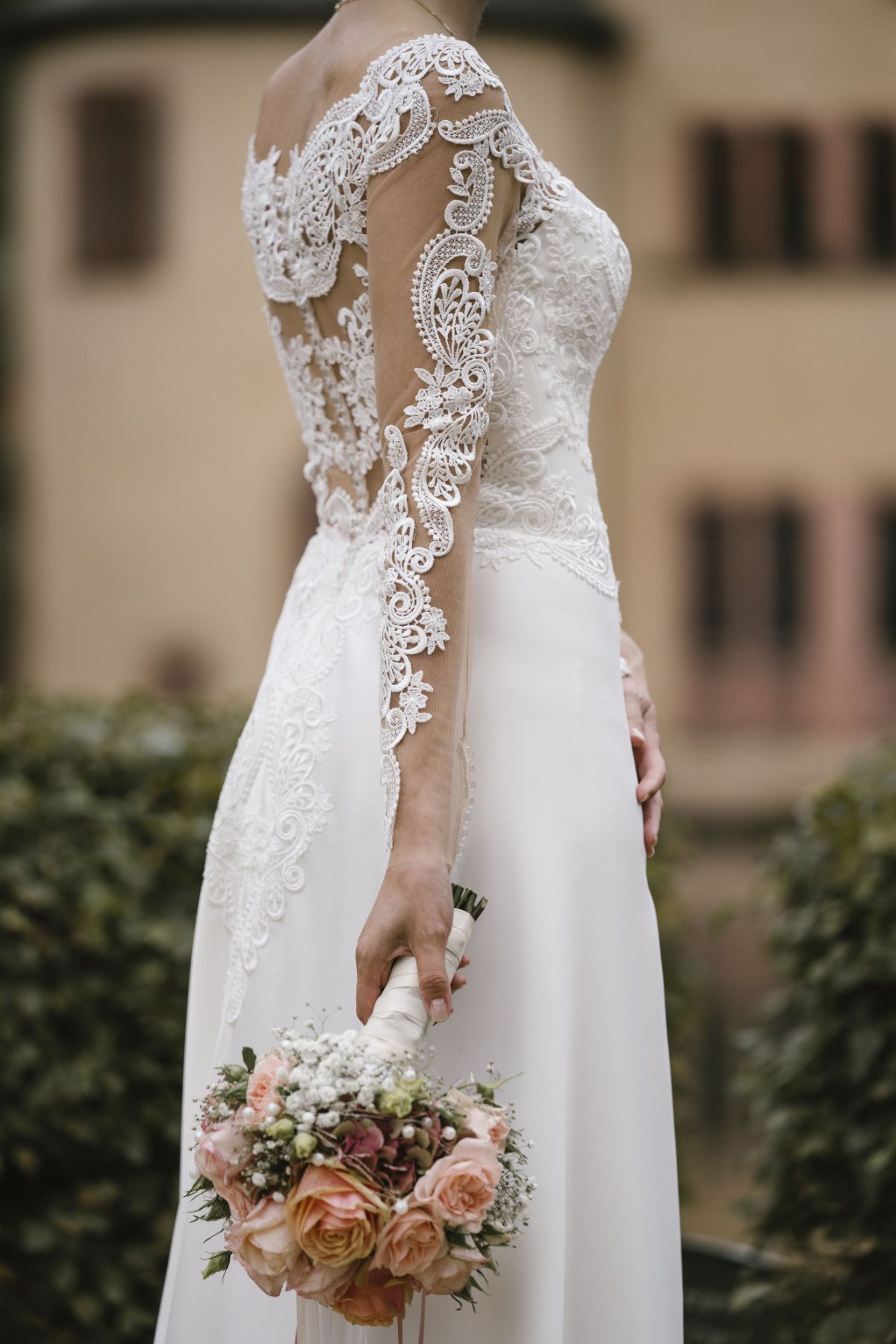 Brautstrauß mit dem Brautkleid im Hintergrund